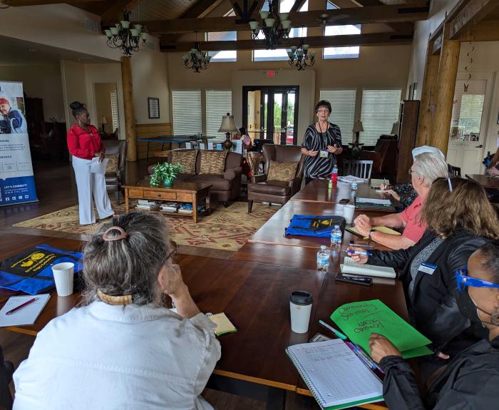 A group of adults sitting at tables listening to a presentation