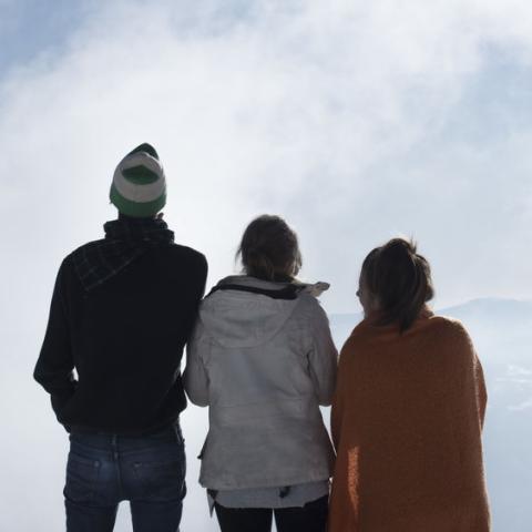 Three youth looking over a horizon