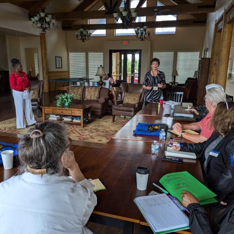 A group of adults sitting at tables listening to a presentation